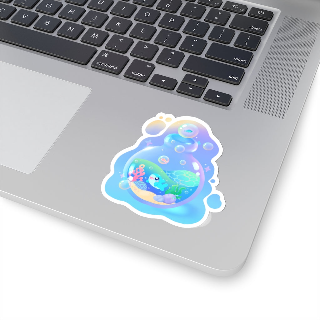 sticker with a cute kawaii illustration of a blue shark swimming in the ocean with bubbles in a potion bottle