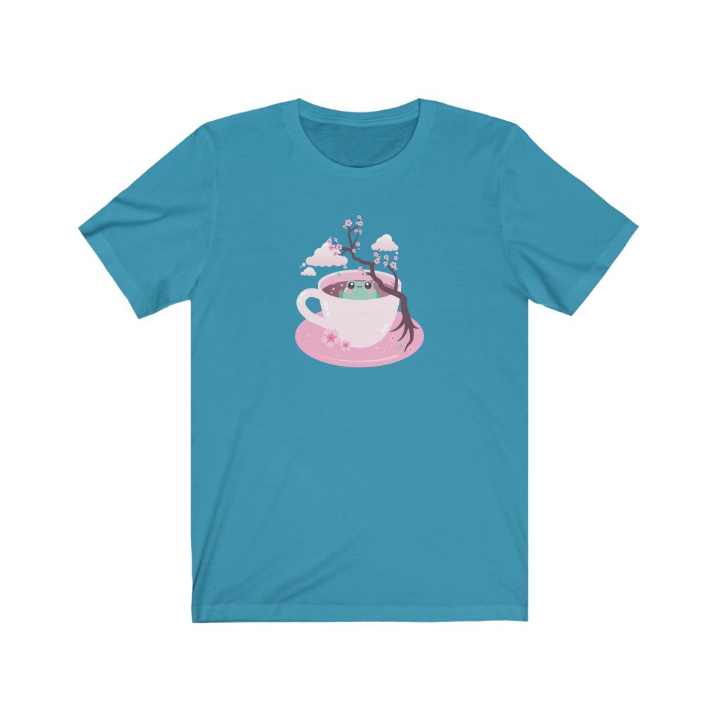 t-shirt with a kawaii cute green grog sitting in a pink tea cup with japanese sakura cherry blossom tree and petals and clouds in the sky