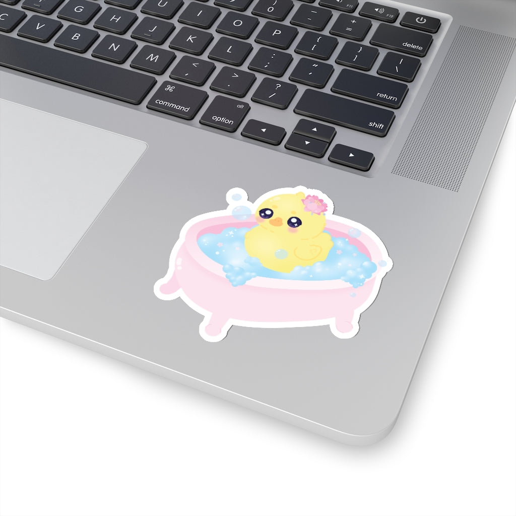 sticker of a cute yellow baby duck in a pink bath tub with blue bubbles and a lotus flower 