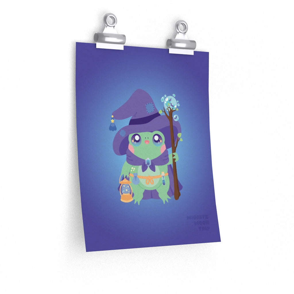 hanging art print of cute green frog with a purple wizard cloak and hat and a magic lantern and staff