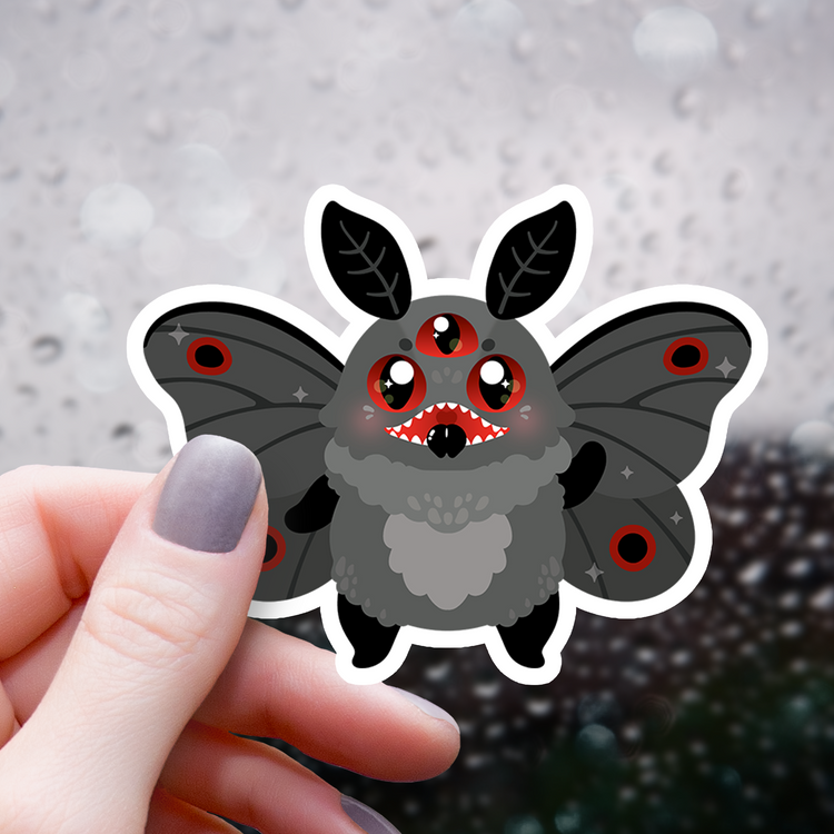 sticker of cute mothman cryptid with glowing red eyes and moth wings