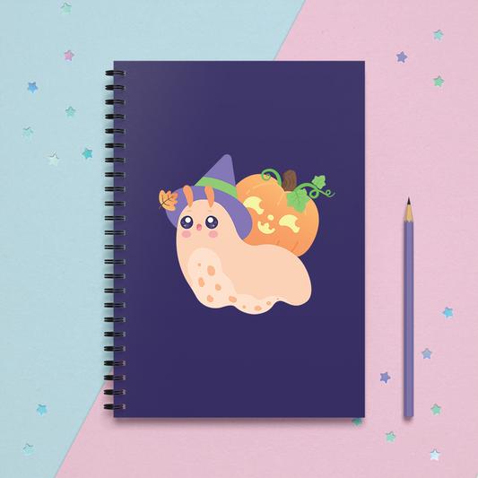 a spiral notebook journal with a kawaii cute snail wearing a witch hat and a halloween jack-o-lantern on its shell